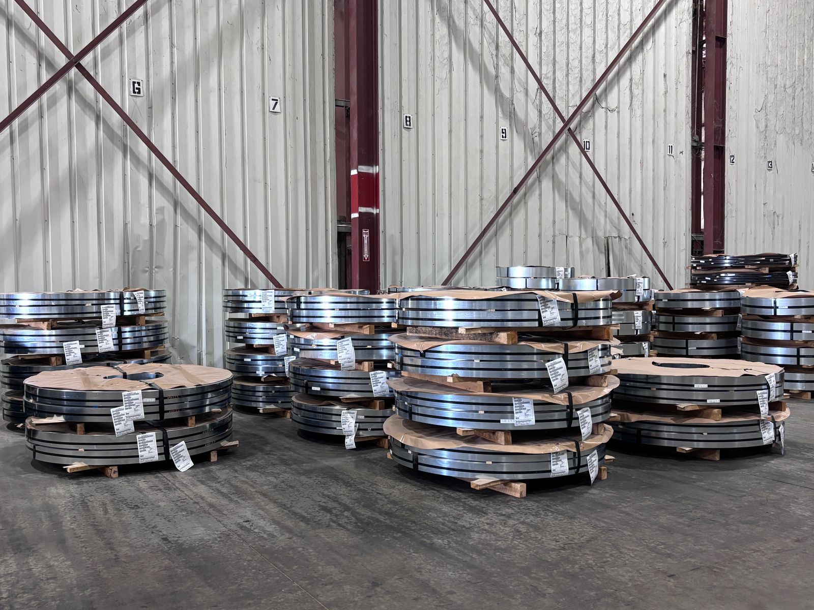 Finished slit-coil inventory staged on pallets inside the warehouse
